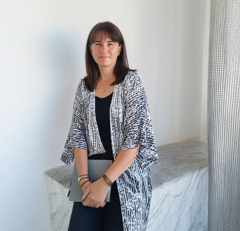 Teresa Gestora Alquiler NRUA. Número de Registro de Alquiler. Rua, nrua, nra, registro de alquiler único ventanilla, teresa gestora de alquiler vacacional, colegio de registradores, turismo, vivienda uso turistico, vut, Airbnb, booking. Vbro. Pms.Mujer profesional posando con una libreta en un espacio interior iluminado EN: Professional woman posing with a notebook in a bright indoor space