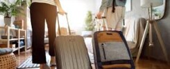 Pareja caminando con maletas en un apartamento de vacaciones. Título: Llegada a un Apartamento de Vacaciones. Couple walking with suitcases into a vacation apartment.. Rua, nrua, nra, registro de alquiler único ventanilla, teresa gestora de alquiler vacacional, registradores.