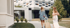 número de registro turístico Valencia España Madrid Barcelona. Rua, nrua, nra, registro de alquiler único ventanilla, teresa gestora de alquiler vacacional, colegio de registradores, turismo, vivienda uso turistico, vut, Airbnb, booking. Vbro. Pms. Dos mujeres con maletas entrando a un alojamiento turístico moderno EN: Two women with suitcases entering a modern tourist accommodation